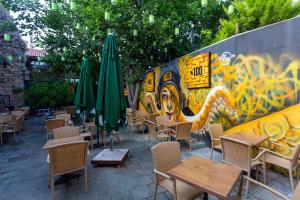 a restaurant with tables and umbrellas in front of a wall at Pera Boutique Hotel in Antalya