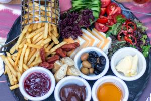 a plate of food with french fries and different dips at Pera Boutique Hotel in Antalya