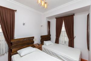a bedroom with two beds and a chandelier at Pera Boutique Hotel in Antalya +15 photos