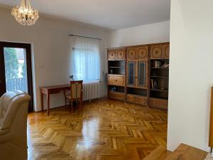 een woonkamer met een houten vloer en een tafel bij Szomszéd Ház in Keszthely