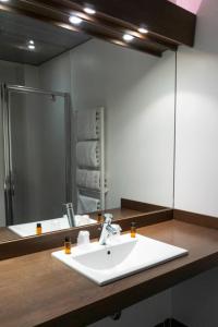 y baño con lavabo y espejo. en Hôtel d'Ossau, en Laruns
