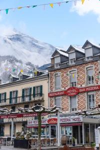 a building with a hotel with a mountain in the background at Hôtel d'Ossau in Laruns