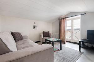 ein Wohnzimmer mit Sofa und Fernseher in der Unterkunft Maison de village L'A N N E X E proche du port in Saint-Martin-de-Ré + 9 Fotos