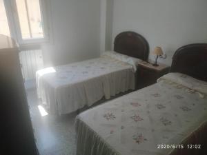 sypialnia z dwoma łóżkami i stołem z lampą w obiekcie La Conchita w mieście Almería