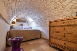 a bedroom with a bed and a dresser at Chianca Bianca in Ostuni