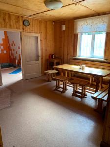 ヤロスラヴリにあるTveritsy Guest Houseの木製テーブルとベンチが備わる空き部屋