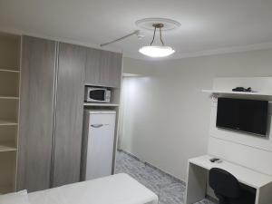 a small kitchen with a refrigerator and a microwave at Brasilia Apart Hotéis in Brasilia