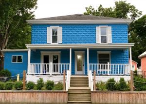 una casa azul con escaleras delante en Devil's Lake Inn and Devil's Lake Inn Too, en Manitou Beach