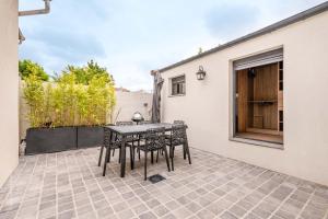 een patio met een tafel en stoelen erop bij THE COSY in Arcueil