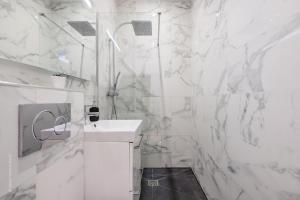 een witte badkamer met een wastafel en een douche bij THE COSY in Arcueil +21 foto's