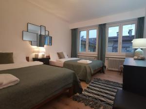 a hotel room with two beds and a window at City Apartment 221 in Merano