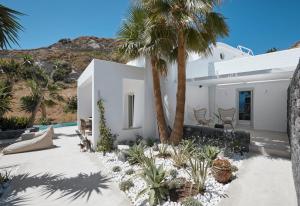 a white house with palm trees and a courtyard at Casa Luz in Pirgos