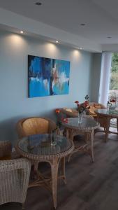 a living room with tables and couches and a painting at Dünenhaus Seensucht in Thiessow