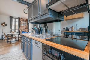 een keuken met blauwe kasten en een aanrecht bij THE COSY in Arcueil