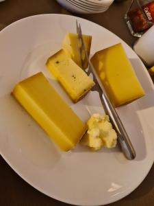 a white plate of cheese on a table at Guesthouse Vögeliwohl in Fluelen