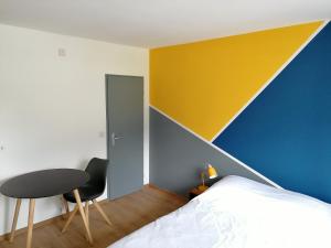Studio vue imprenable في سييرا: غرفة نوم بسرير وجدار اصفر وزرق