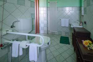 a bathroom with a toilet and a sink with towels at All'Ombra del Castello in Cigliè