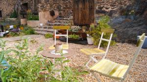 2 chaises et une table dans un jardin dans l'établissement Hotel Rural Las Campares, à Callejo de Ordás