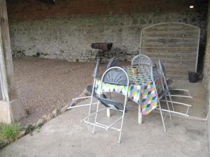 Dos sillas y una mesa con una manta. en Gîte cosy 4 à 9 personnes, en Buffières