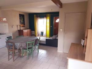 a kitchen and dining room with a table and chairs at Gîte cosy 4 à 9 personnes in Buffières