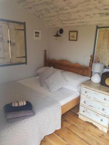 um quarto com uma cama e uma cómoda com um espelho em The Shepherds Snug em Faversham