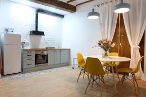 a kitchen with a table and yellow chairs at LA MOMA Apartments & Room in Xàtiva