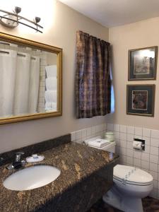 a bathroom with a sink and a toilet and a mirror at Port Angeles Inn in Port Angeles