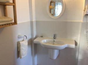 ein weißes Badezimmer mit einem Waschbecken und einem Spiegel in der Unterkunft VIVIENDAS ES CARNATGE in Playa Migjorn