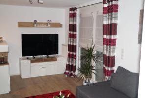 a living room with a flat screen tv and curtains at Ferienwohnung Murg Niederhof in Murg