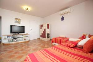 a bedroom with two beds and a flat screen tv at Apartment Jelka- center of Hvar town in Hvar