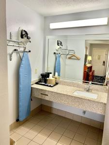 La salle de bains est pourvue d'un lavabo et d'un miroir. dans l'établissement Scottish Inns Westcott Street, à Houston