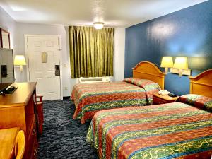 a hotel room with two beds and a window at Scottish Inns Westcott Street in Houston