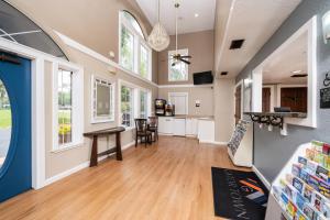 een keuken en een woonkamer met een tafel en ramen bij GatorTown Inn in Gainesville