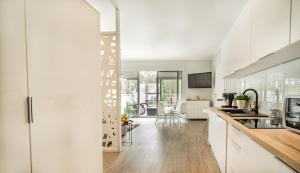 a kitchen with white cabinets and a dining room at Baltic 4YOU 2 in Pobierowo