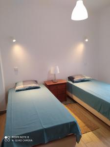 アルブフェイラにあるParadise in Olhos D'água Beachのベッドルーム1室(隣り合わせのベッド2台付)