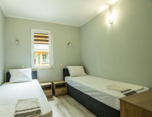 a small room with two beds and a window at Бунгала Сън Сити in Sandanski +28 photos
