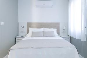1 dormitorio blanco con 1 cama blanca grande y 2 lámparas en Sosiego Home, en Puerto de Mazarrón