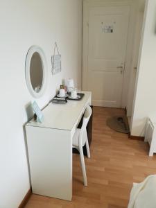 a white dressing table with a mirror and a chair at Guesthouse Fatuta in Cres