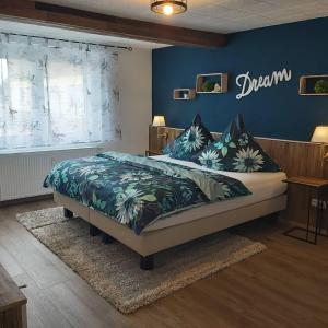 Apart Hotel - Dillinger Schwabennest في ديلينغن أن در دوناو: غرفة نوم بسرير مع جدار ازرق