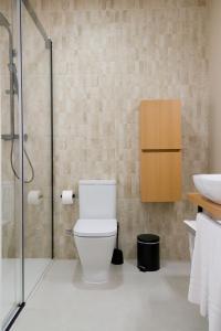 a bathroom with a toilet and a glass shower at Sosiego Home in Puerto de Mazarrón +24 photos