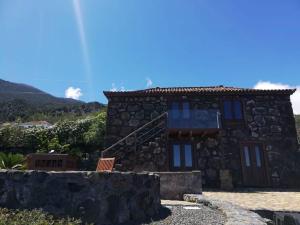 a stone house with a staircase in front of it at Casa Rural Quinta Los Naranjos in Tigalate