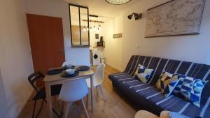 een woonkamer met een bank en een tafel bij Près des Bassins, Appartement 35m2 hyper centre Honfleur in Honfleur