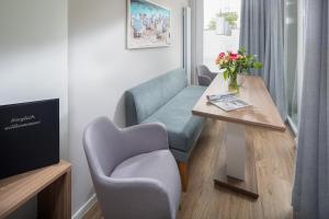 a living room with a blue chair and a table at Düsseldorfer Hof Norderney A1 in Norderney