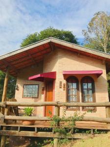 a small house with a fence in front of it at Pousada Vinhas do Pinhal in Santo Antônio do Pinhal