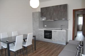 kuchnia ze stołem, białymi krzesłami i zlewem w obiekcie Locazione Turistica Elite Parco Brentelle bed & breakfast - Chiesanuova 135 e 167 w Padwie