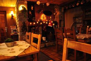 a dining room with a table and chairs and a fireplace at La Foret De Maronne in La Garde