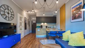 un soggiorno con divano blu e una cucina di Apartament Nastrojowy-Holiday Mountain Residence - 5D Apartamenty a Świeradów-Zdrój