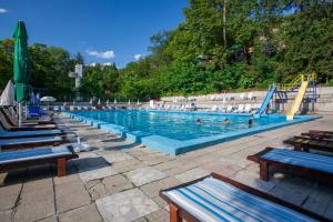 a large swimming pool with a slide and people in it at Бунгала Сън Сити in Sandanski