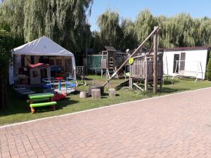 a playground with a play set and a tent at Domki Letniskowe 777 in Karwia