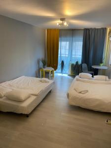um quarto com 2 camas, uma mesa e cadeiras em green Apartment 96 em Bucareste